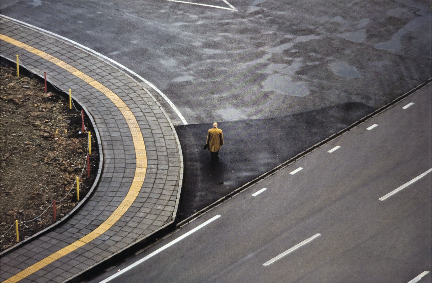 overhead view of figure crossing a street below